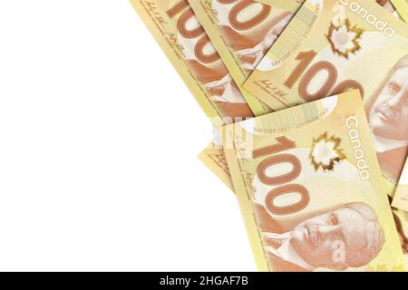 A directement au-dessus de l'image de billets de cent dollars canadiens nets de 100 sur fond blanc.Les billets sont empilés au hasard l'un sur l'autre. Banque D'Images