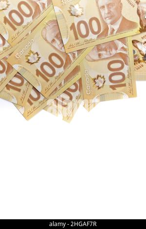 A directement au-dessus de l'image de billets de cent dollars canadiens nets de 100 sur fond blanc.Les billets sont empilés au hasard l'un sur l'autre. Banque D'Images