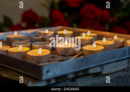 Bougies de prière brûlantes à l'intérieur d'une église catholique.Lumières à thé allumées.Mise au point sélective. Banque D'Images