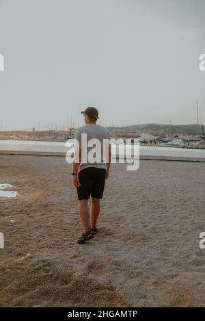 Un homme marche le long de la mer au coucher du soleil.Repos solitaire Banque D'Images