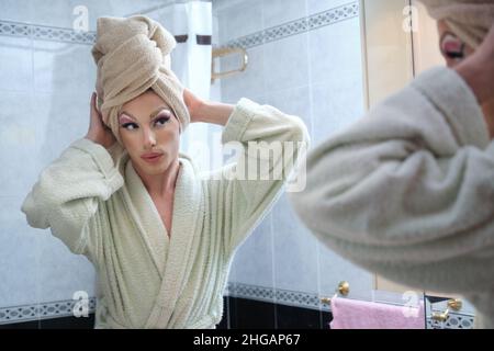 Faites glisser la personne de grand lit se préparer après la douche devant le miroir de salle de bains. Banque D'Images