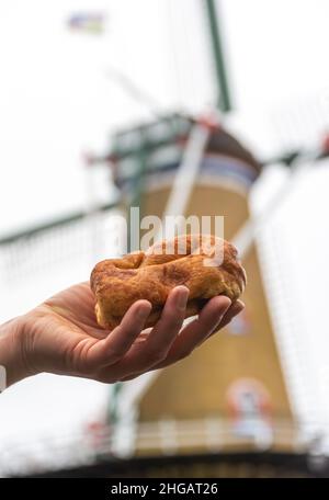 Pâtisserie hollandaise traditionnelle de la province de Zélande appelée Zeeuwse Bolus, exposée devant le moulin à vent historique Banque D'Images