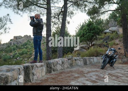 Un beau homme qui prend une photo pendant son voyage en moto Banque D'Images