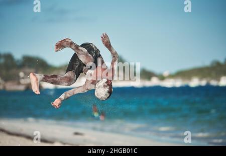 Action acrobatioc saut de jeune africain.Rotation aérienne de Am man sur la plage à Watamu Kenya, Afrique jeune homme saut arrière-flip noir blanc Banque D'Images