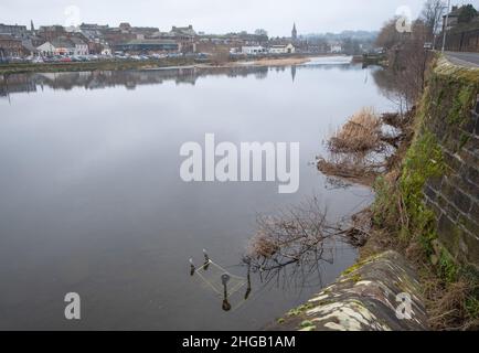 Une vue sur la rivière Nith dans le centre-ville de Dumfries, en Écosse avec un chariot de shopping et des débris au premier plan. Banque D'Images