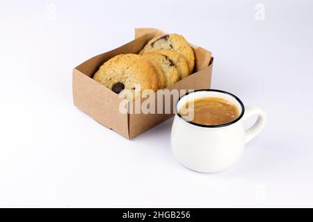 Café noir chaud avec de la mousse et des biscuits au chocolat doux dans une boîte de papier kraft sur fond blanc.Partie de l'ensemble. Banque D'Images