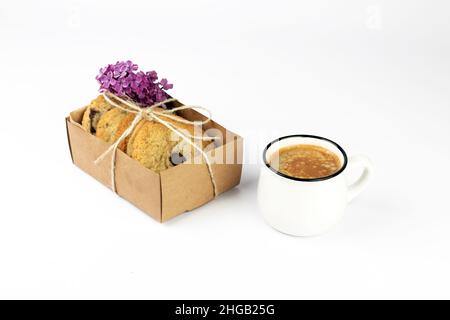 Café noir chaud avec de la mousse et des biscuits au chocolat doux dans une boîte de papier kraft sur fond blanc.Partie de l'ensemble. Banque D'Images