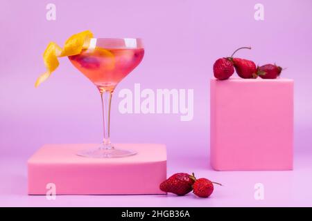 Cocktail d'été avec fraises sur fond rose et podium rose.Concept abstrait de boisson d'été rafraîchissante. Banque D'Images