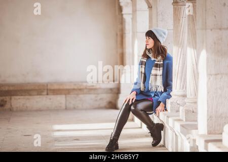 Jeune UNE touriste en manteau bleu tendance sur le mur du Bastion des pêcheurs du château de Buda à Budapest, Hongrie en hiver Banque D'Images