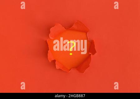 Papier déchiré rouge avec espace pour le texte sur fond rouge.Point d'interrogation. Banque D'Images