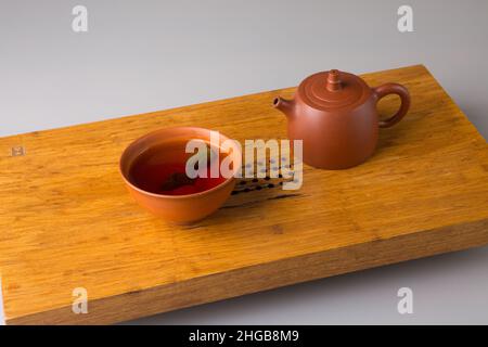 Théière et tasse avec thé pu-erh fraîchement préparé.Un set sur une table en bois pour les cérémonies du thé. Banque D'Images