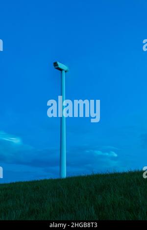 Centrale éolienne sur pelouse verte.Photo au coucher du soleil.Il y a de beaux nuages bleus dans le ciel. Banque D'Images