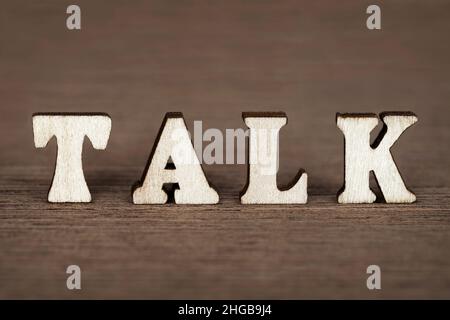 Mot « talk » composé de lettres en bois sur fond de bois. Banque D'Images