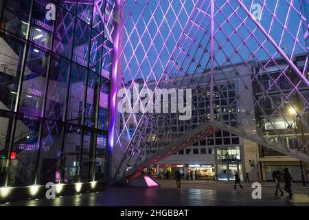 L'atrium du 55 Baker Street, Londres, présente des lumières violettes entre les panneaux de verre et semble impressionnant au crépuscule lorsque les piétons et les bus passent Banque D'Images