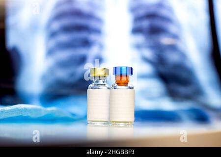 Deux flacons de vaccin avec étiquette vierge sur fond médical bleu clair irm avec espace de copie.Soins de santé, immunisation, virus ou maladie infectieuse préc Banque D'Images