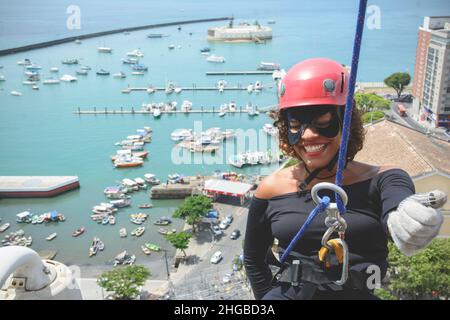 Une femme portant un costume de héros avec un casque de protection marchant dans un grand bâtiment de Rappel.Salvador Bahia Brésil. Banque D'Images