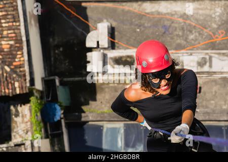 Une femme portant un costume de héros avec un casque de protection marchant dans un grand bâtiment de Rappel.Salvador Bahia Brésil. Banque D'Images