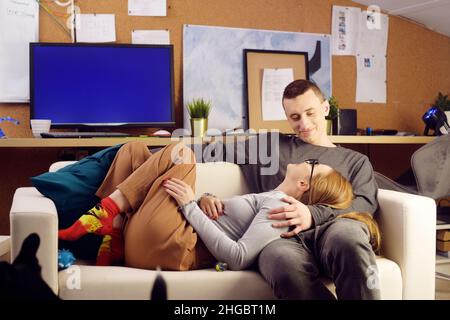 Le couple est allongé sur le canapé et parle.Les amoureux ne font rien, passent un endroit ensemble, rient. Banque D'Images