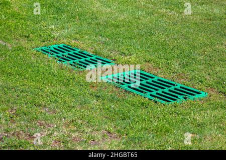 bac de récupération de la grille de drainage sur la pelouse avec l'herbe verte de la fosse septique, deux rectangulaire vert eco trappes puisards such système de drainage environnement Banque D'Images