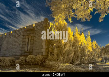 Photographie infrarouge du paysage de cimetière avec une crypte et des arbres.Utilisation d'un appareil photo Nikon IR converti. Banque D'Images