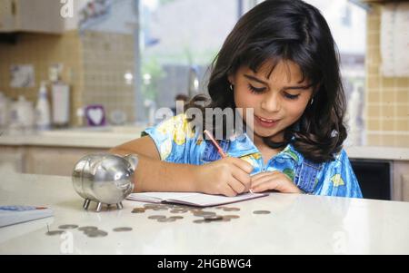 Austin, Texas USA: Anglo-Panamian fille, 8 ans, prépare un dépôt de compte d'épargne à la maison.M. ER-168 ©1998 Bob Daemmrich Banque D'Images