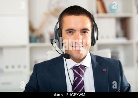Homme souriant assistance clientèle opérateur téléphonique avec casque Banque D'Images
