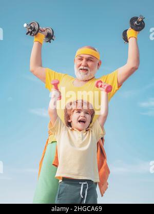 Éducation sportive.Le père et le fils.Un mode de vie familial sain.Garçon fait des exercices pour développer des muscles.Suivez le grand-père. Banque D'Images