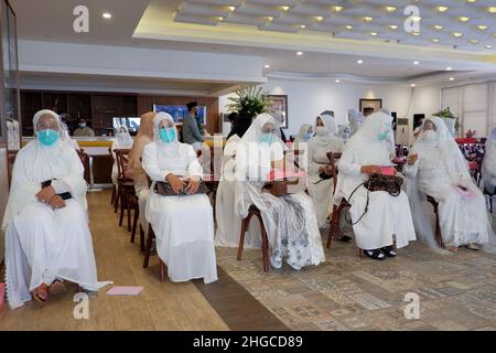 Jakarta, Indonésie - décembre 2020 : Un groupe de femmes musulmanes porte un masque et un masque facial dans une pièce. Banque D'Images