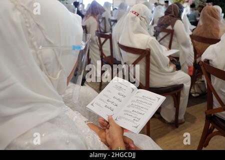 Jakarta, Indonésie - décembre 2020 : Un groupe de femmes musulmanes porte un masque facial et lit des livres de prière dans une salle Banque D'Images