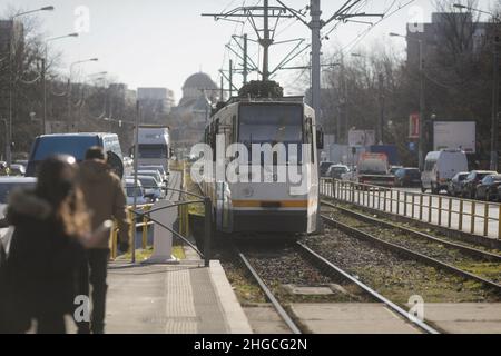 Bucarest, Roumanie - 19 janvier 2022 : un vieux tramway arrive dans une gare sur un boulevard de Bucarest par une belle journée d'hiver. Banque D'Images