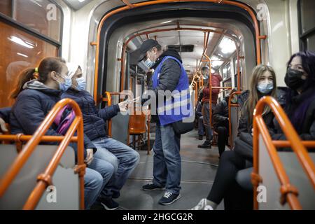 Bucarest, Roumanie - 19 janvier 2022 : Man vérifie les billets de transport à l'intérieur d'un ancien tramway à Bucarest. Banque D'Images