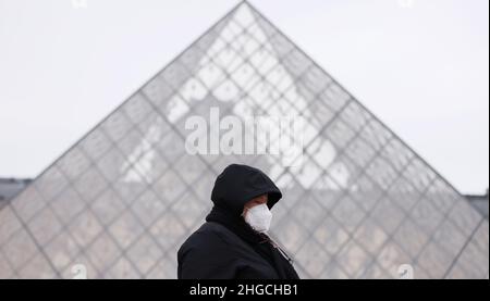 Paris, France.19th janvier 2022.Une femme passe devant la pyramide du Musée du Louvre à Paris, France, le 19 janvier 2022.La situation de la COVID-19 continue de s'aggraver en France, car 464 769 nouveaux cas ont été détectés au cours des 24 dernières heures, comme l'a annoncé mardi l'agence de santé publique du pays.Credit: Gao Jing/Xinhua/Alamy Live News Banque D'Images