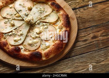 Pizza aux poires et au fromage Gorgonzola, pizza italienne à la poire et au fromage bleu sur fond de bois. Banque D'Images