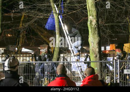 Hambourg, Allemagne.20th janvier 2022.Un activiste monte une échelle à partir d'un arbre.Les activistes ont protesté tôt jeudi matin contre l'abattage d'arbres à Neuer Pferdemarkt, à Saint-Pauli.Trois personnes avaient grimpé dans les arbres pour empêcher le travail d'abattage, a déclaré la police.En outre, plusieurs autres militants se sont rassemblés sur le site.Crédit : Bodo Marks//dpa/Alay Live News Banque D'Images