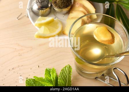 Tasse de thé vert avec citron au gingembre et menthe sur table en bois avec feuilles sur table en bois.Vue en hauteur. Banque D'Images
