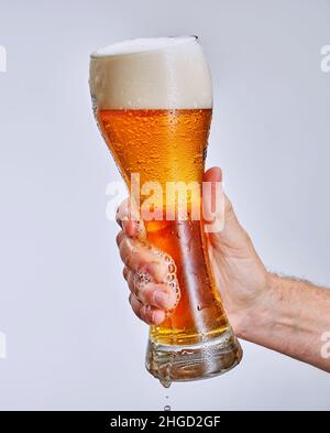 main tenant un verre de bière, isolé sur fond blanc Banque D'Images