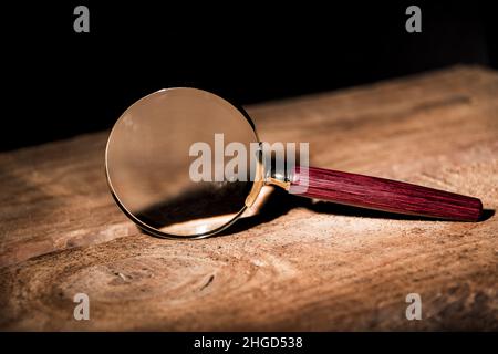 Close up seule Loupe avec poignée noire, se penchant sur la table en bois au bureau. Banque D'Images