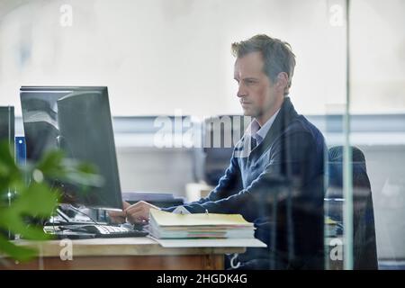 Faire son travail.Photo rognée d'un jeune designer élégant travaillant sur un pc. Banque D'Images