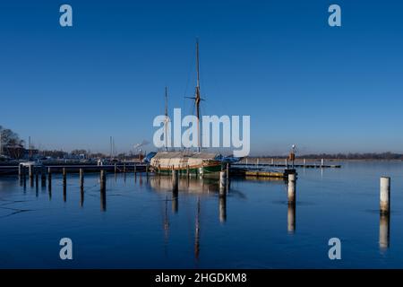 Un voilier dans une marina fermé pour l'hiver.Eau bleue et ciel bleu clair Banque D'Images