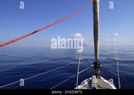 Yacht aproaching l'île volcanique de Stromboli lors d'une journée calme Banque D'Images