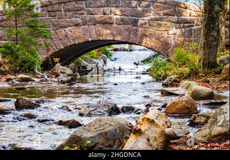 L'eau s'écoulant de Jordon's Pond sous un pont en pierre historique sur le sentier autour de l'étang dans le parc national d'Acadia, Maine, États-Unis Banque D'Images