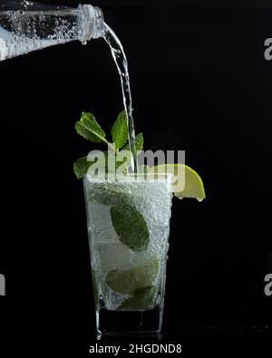 Un verre d'eau pétillante à la menthe et une tranche de lime Banque D'Images