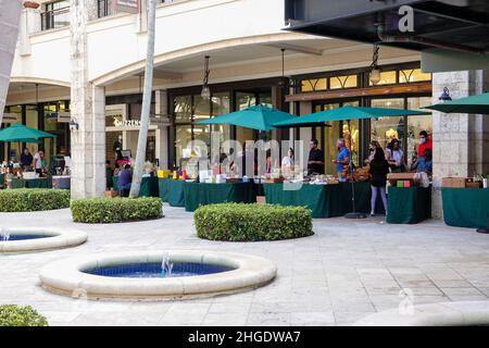 Les gens magasinent dans des stands situés dans la zone extérieure ouverte des boutiques de Merrick Park, centre commercial haut de gamme de Coral Gables, Floride, États-Unis. Banque D'Images