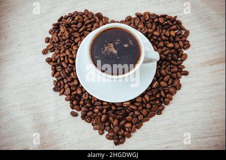 Tasse de café.Grains de café en forme de coeur. grains de café isolés sur fond blanc. Grains de café torréfiés, peuvent être utilisés comme fond. Banque D'Images