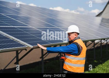 L'employé de la centrale solaire vérifie l'état des panneaux Banque D'Images