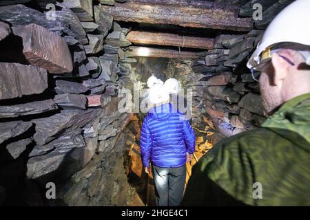 touristes entrant dans le quartier des lacs de la mine d'ardoise honister, cumbria, angleterre, royaume-uni Banque D'Images