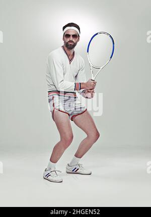 Prêt pour votre service.Portrait d'un jeune joueur de tennis rétro dans le studio. Banque D'Images