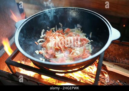 Faire frire les carottes avec les oignons dans le chou-fleur au feu Banque D'Images