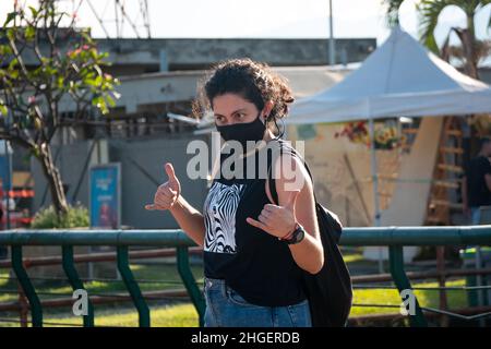 Medellin, Antioquia, Colombie - décembre 7 2021 : femme aux cheveux bouclés portant des vagues de masque noir avec ses mains Banque D'Images