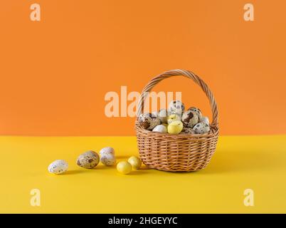 caille les œufs dans un panier sur fond jaune et orange Banque D'Images